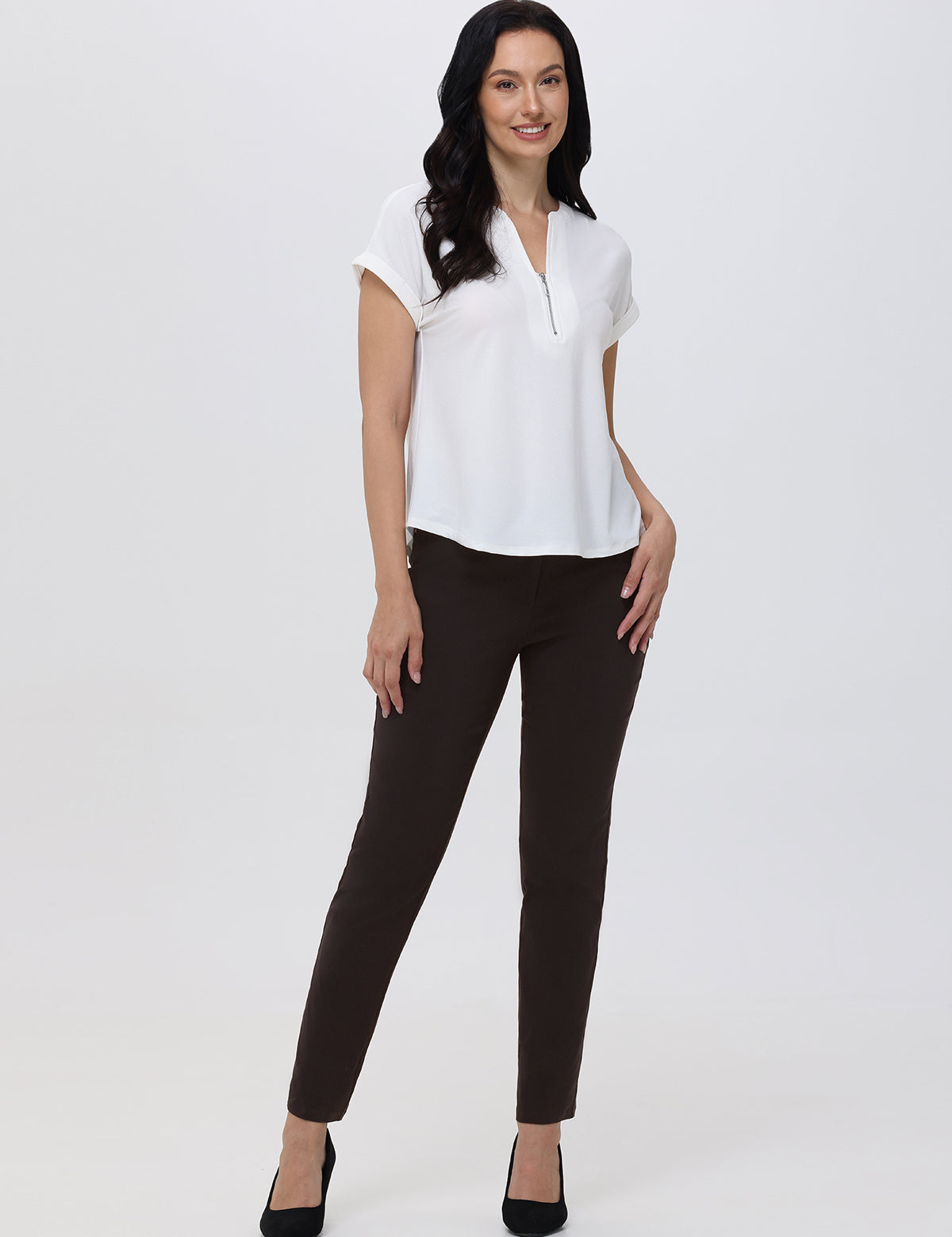Woman wearing a white blouse and brown pants on a white background