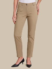 A model wearing a pair of slim-fit, straight-leg cropped pants in a light tan/khaki color, styled with black pointed-toe heels against a solid beige background.