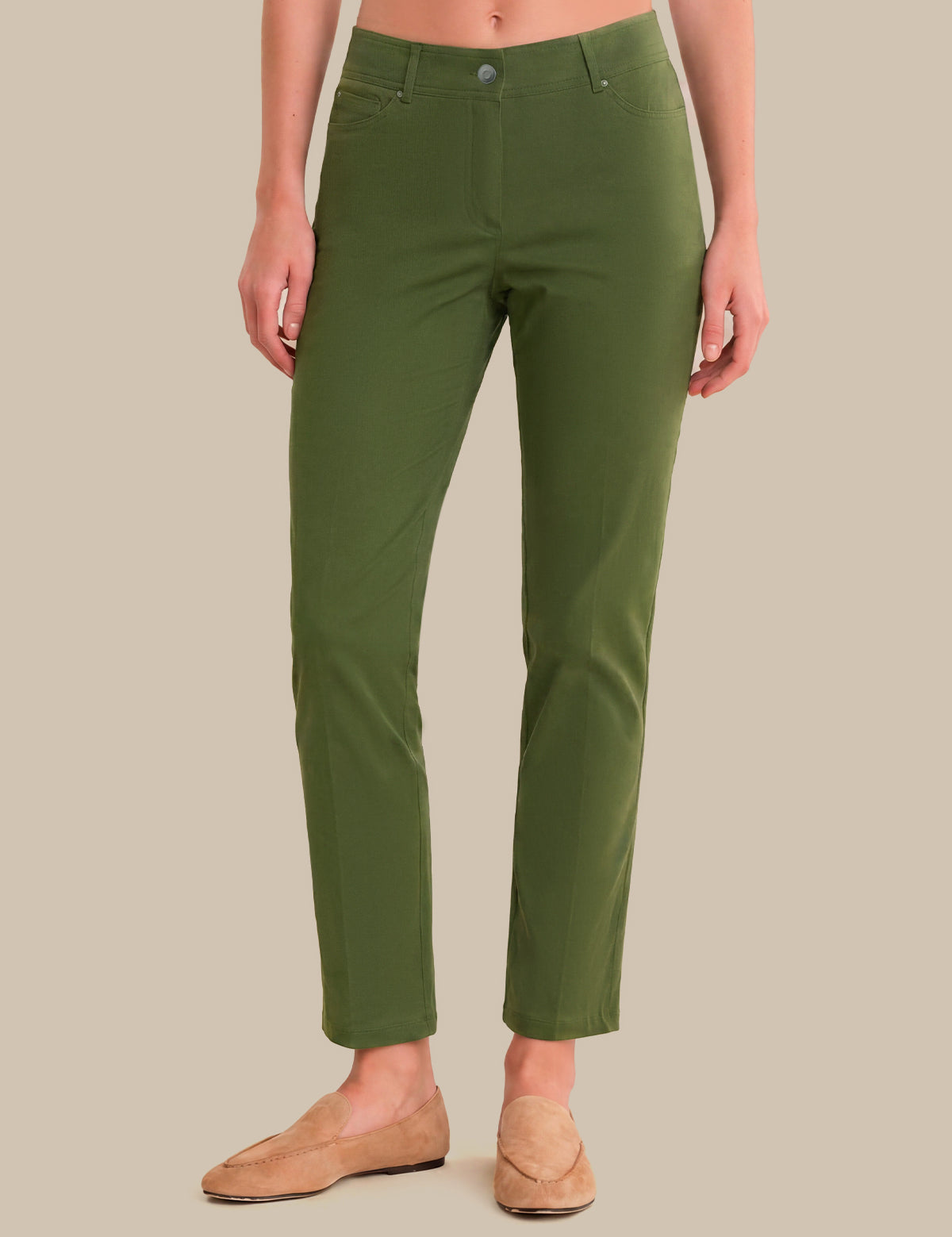 A model wearing olive green cropped pants and tan loafers, shown from the waist down against a solid beige background.