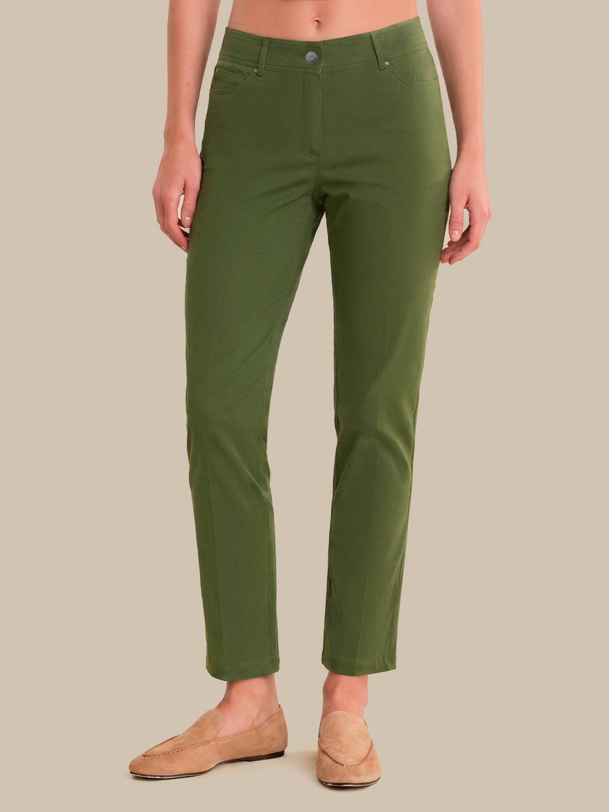 A model wearing olive green cropped pants and tan loafers, shown from the waist down against a solid beige background.