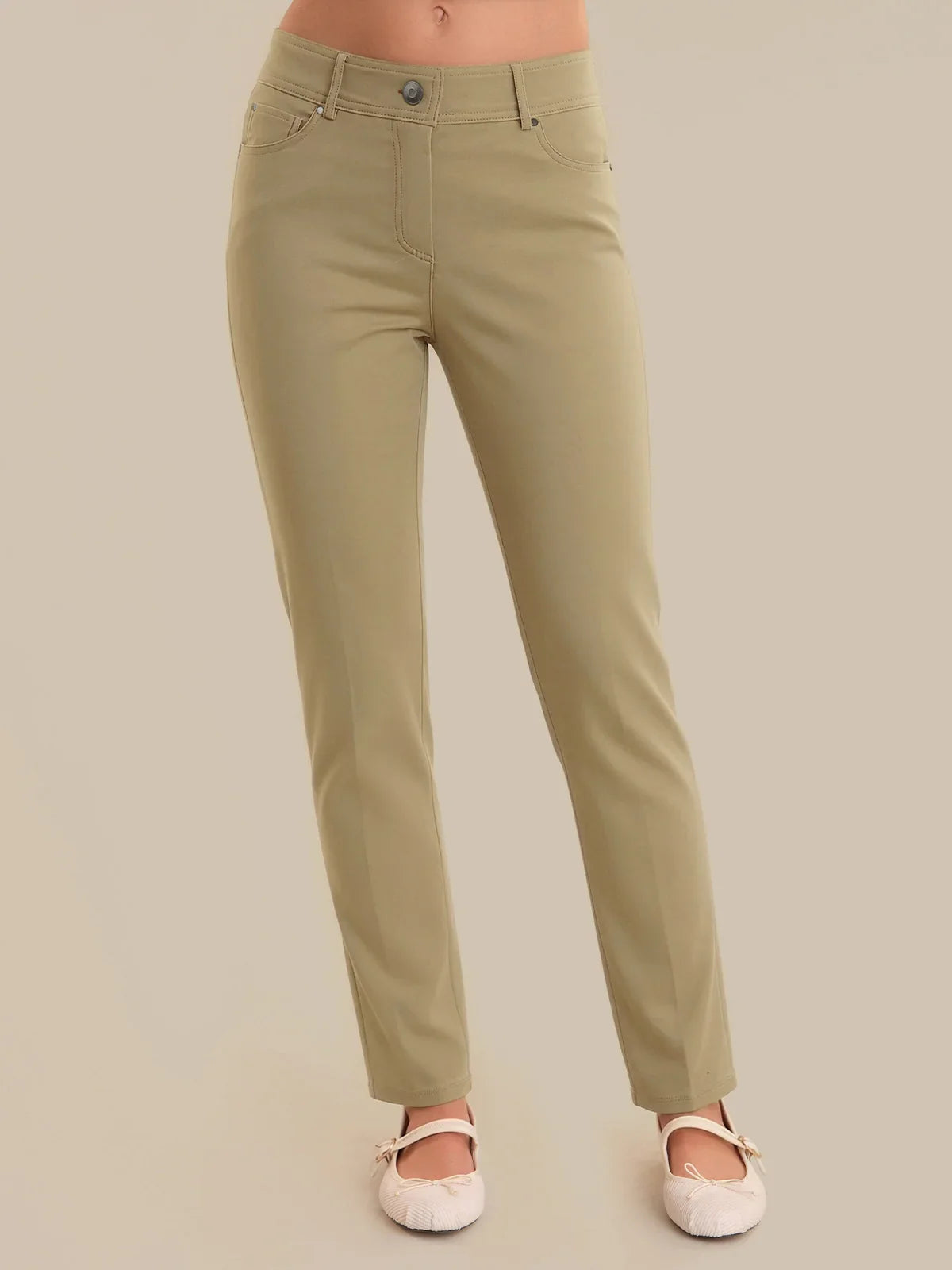 Khaki pants worn by a person on a beige background