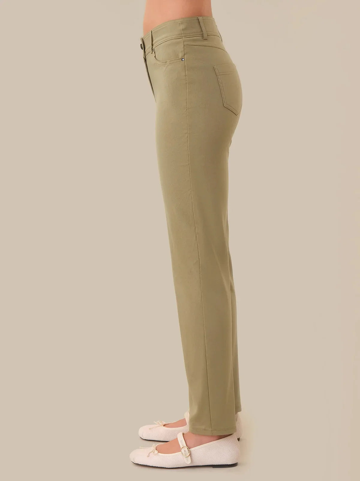 Khaki pants worn by a person on a beige background