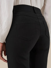 Black pants with a white shirt on a neutral background
