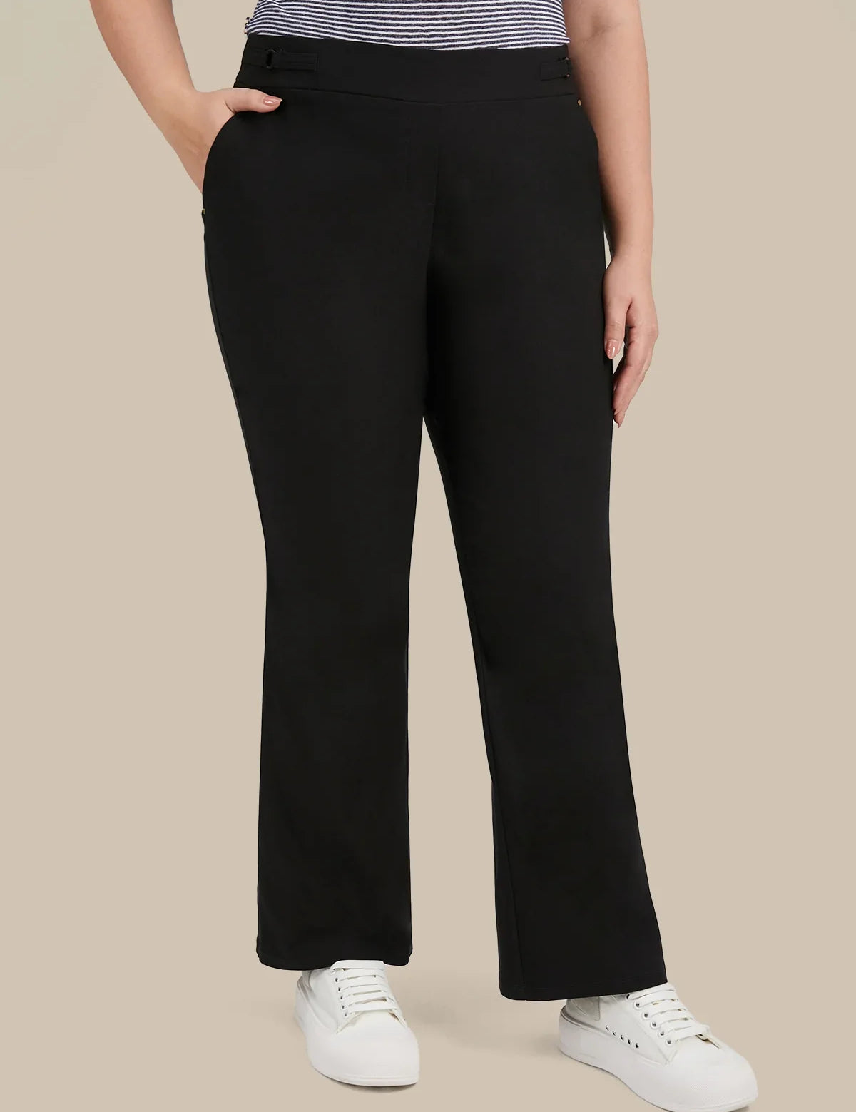 A model wearing black wide-leg cropped pants with a striped top and white sneakers, shown from the waist down against a solid beige background.