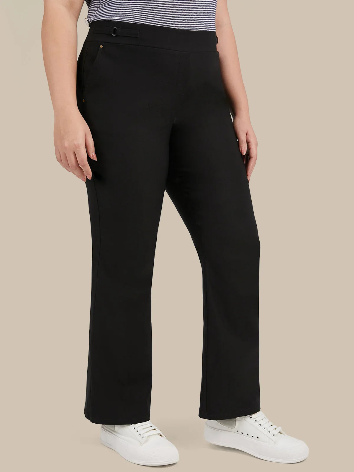 A model wearing black wide-leg cropped pants, a striped top, and white sneakers, shown from the waist down against a solid beige background.