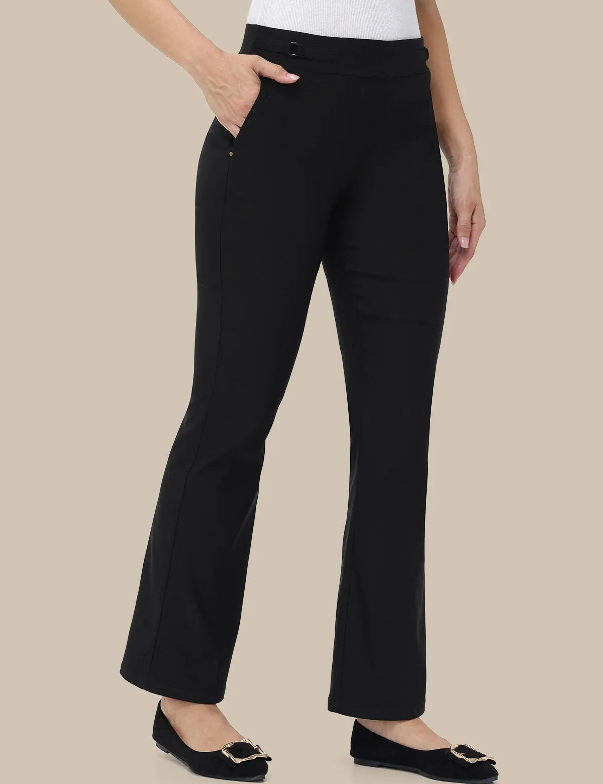 Black wide-leg cropped pants with side pockets, shown on a model wearing a white top and black flats against a solid beige background.