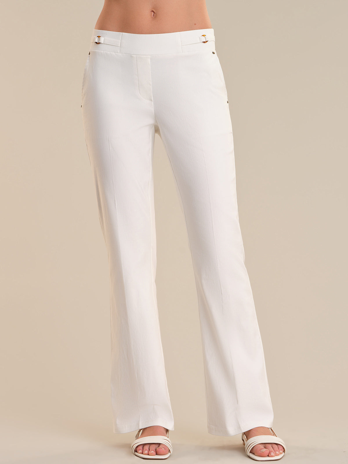 White pants worn by a person on a beige background