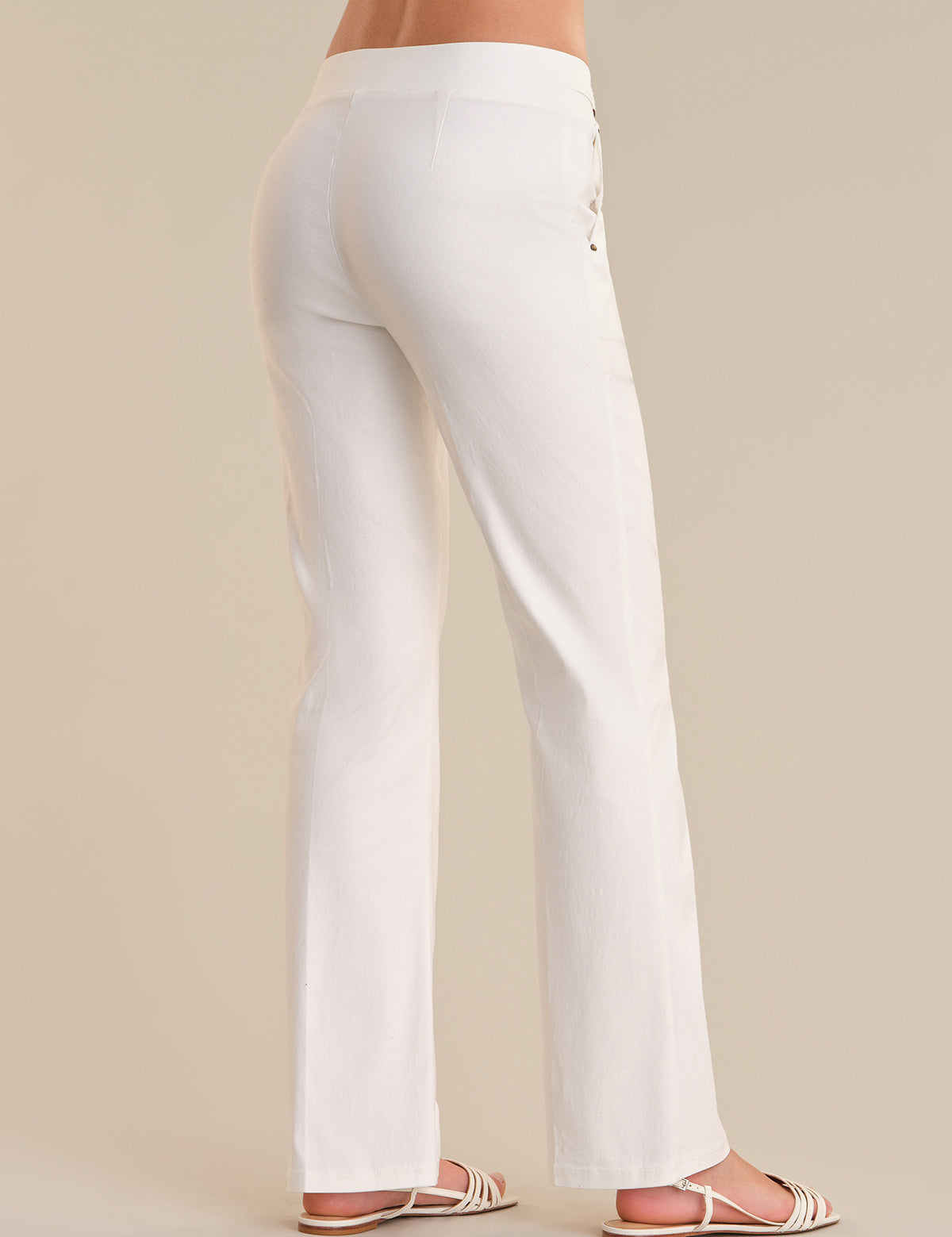 White pants worn by a person on a beige background