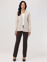 Woman wearing a beige blazer over a white top and brown pants on a white background