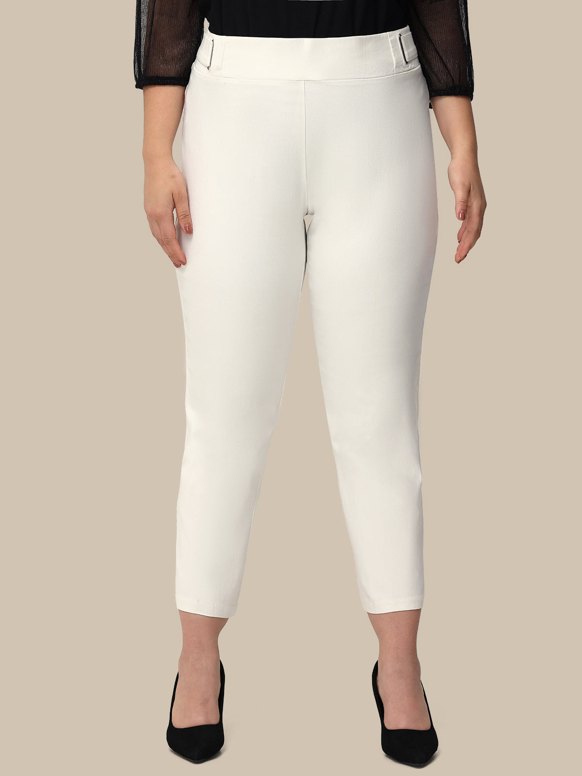 White pants worn by a person on a beige background