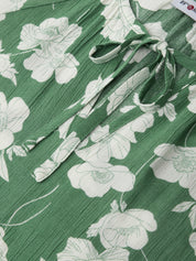Green fabric with white floral pattern and tied bow