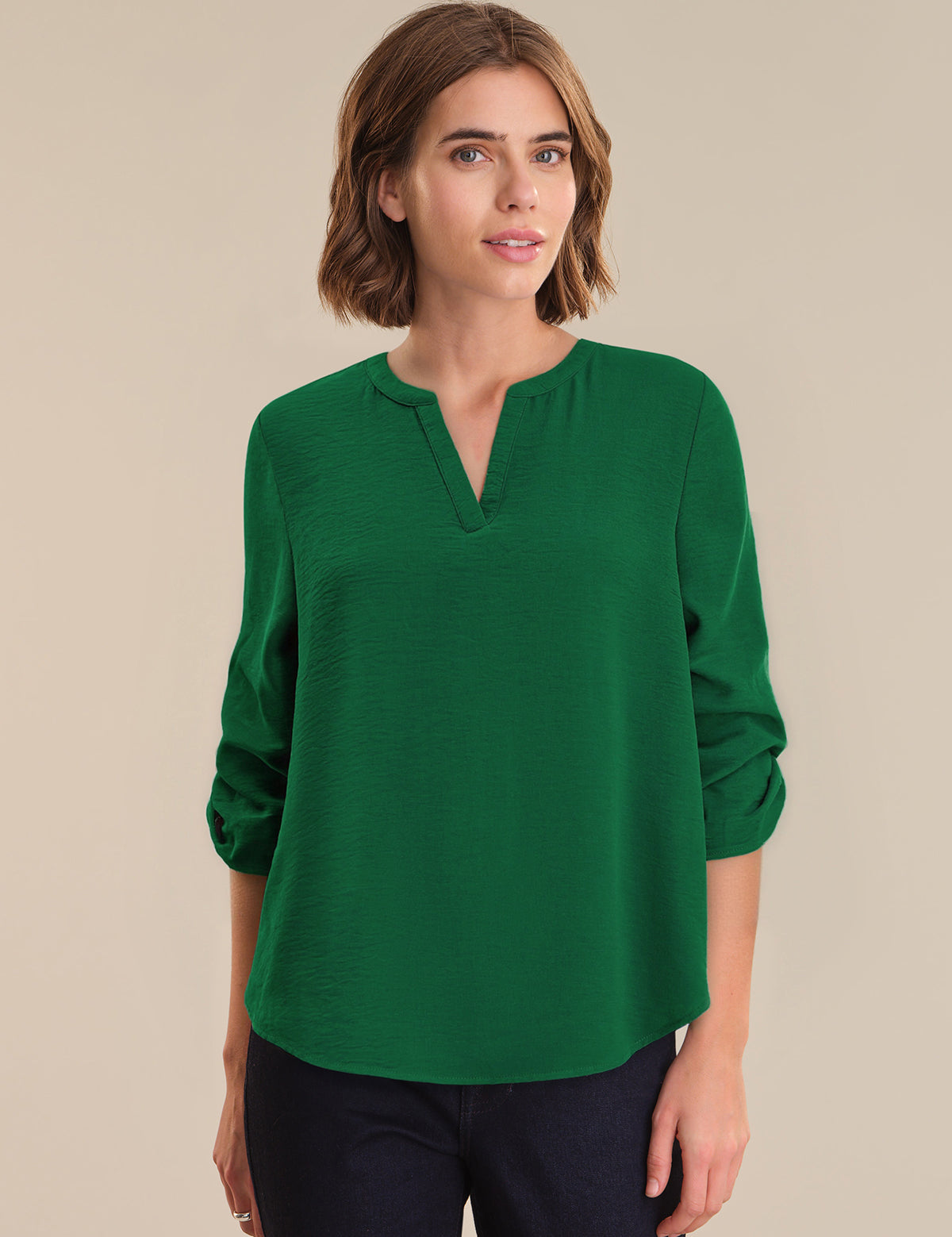Woman wearing a green blouse against a beige background