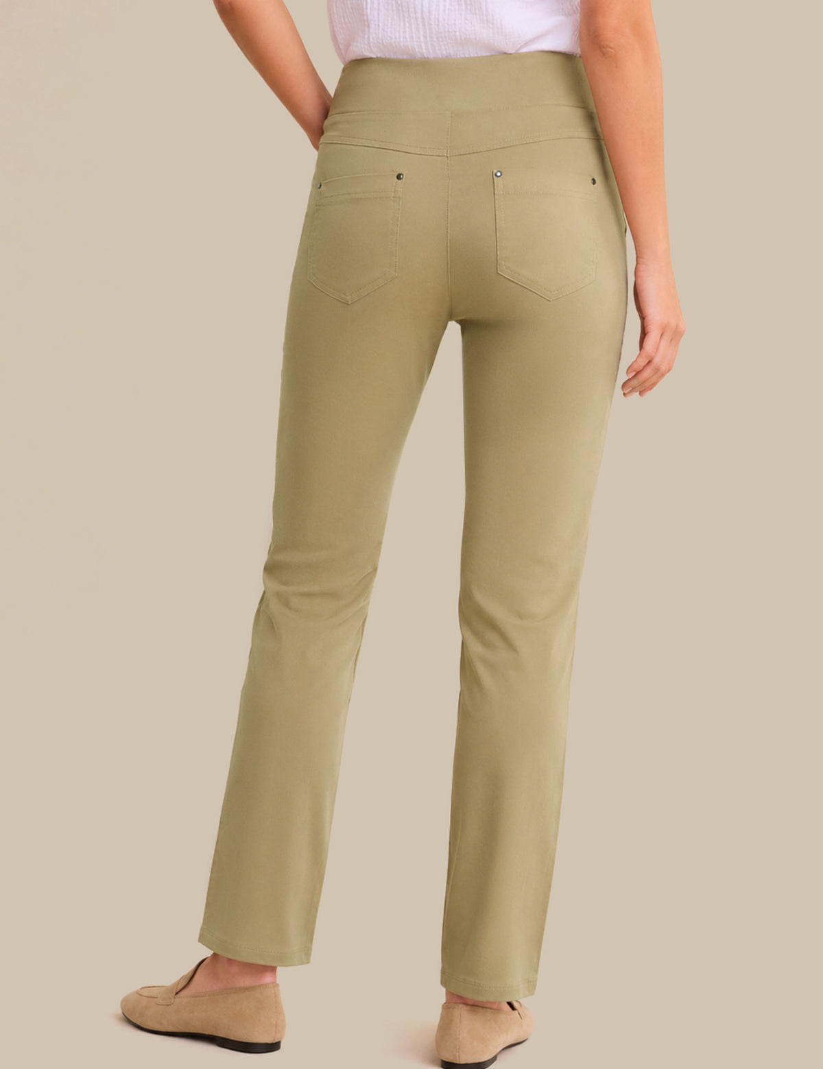 Person wearing olive green pants on a beige background