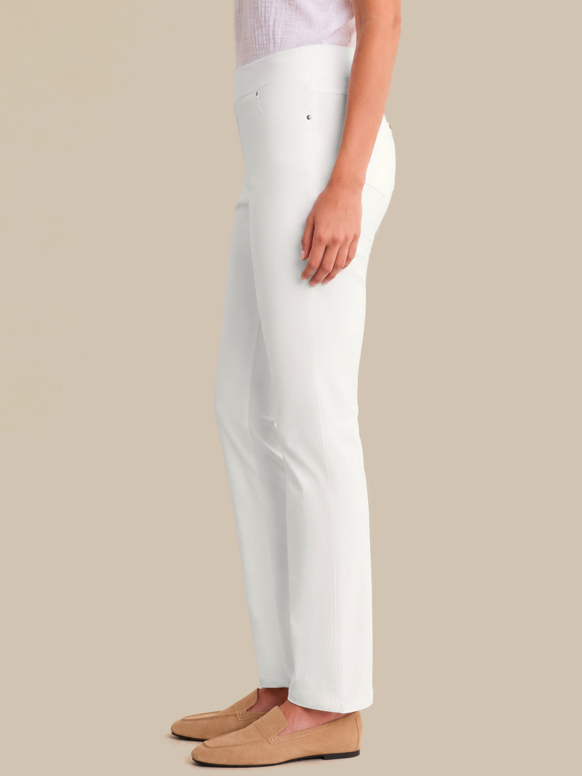 White pants worn by a person on a beige background