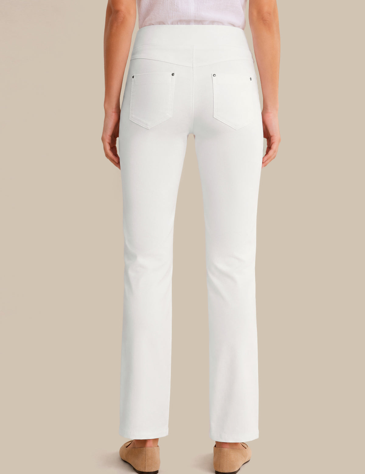 White pants worn by a person on a beige background