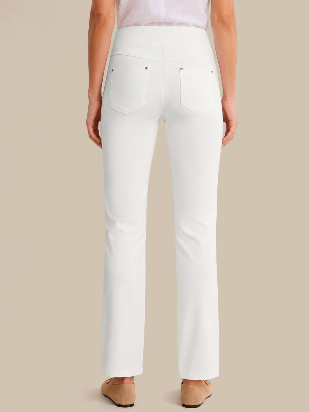 White pants worn by a person on a beige background