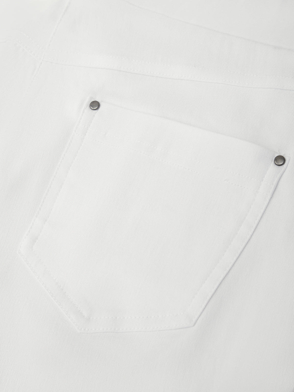 Close-up of a white shirt with button details on a light gray background