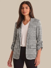 Woman wearing a checkered blazer over a white shirt on a beige background