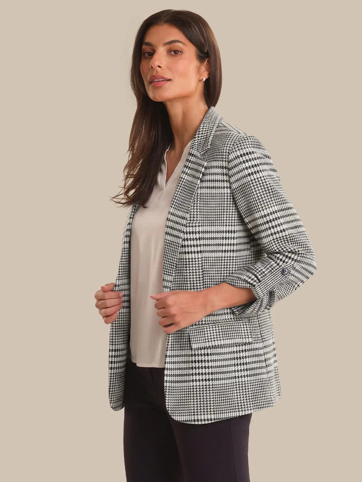 Woman wearing a checkered blazer on a beige background
