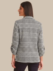 Woman wearing a black and white checkered blazer on a beige background