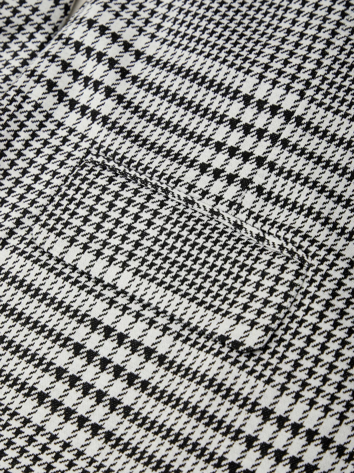 Close-up of a black and white houndstooth pattern fabric texture.