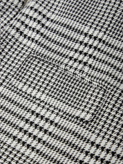 Close-up of a black and white houndstooth pattern fabric texture.