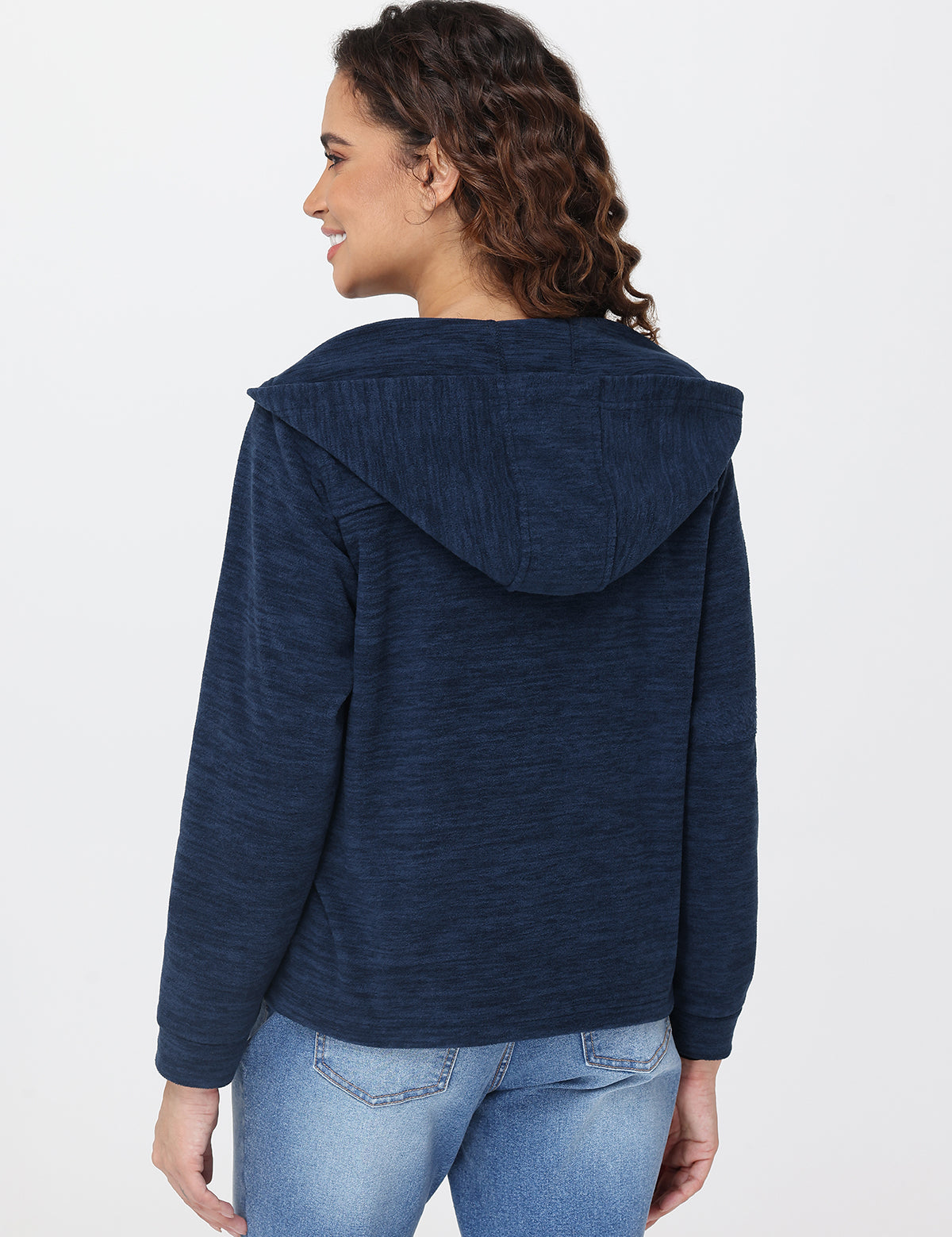 Woman wearing a blue hoodie and jeans on a white background