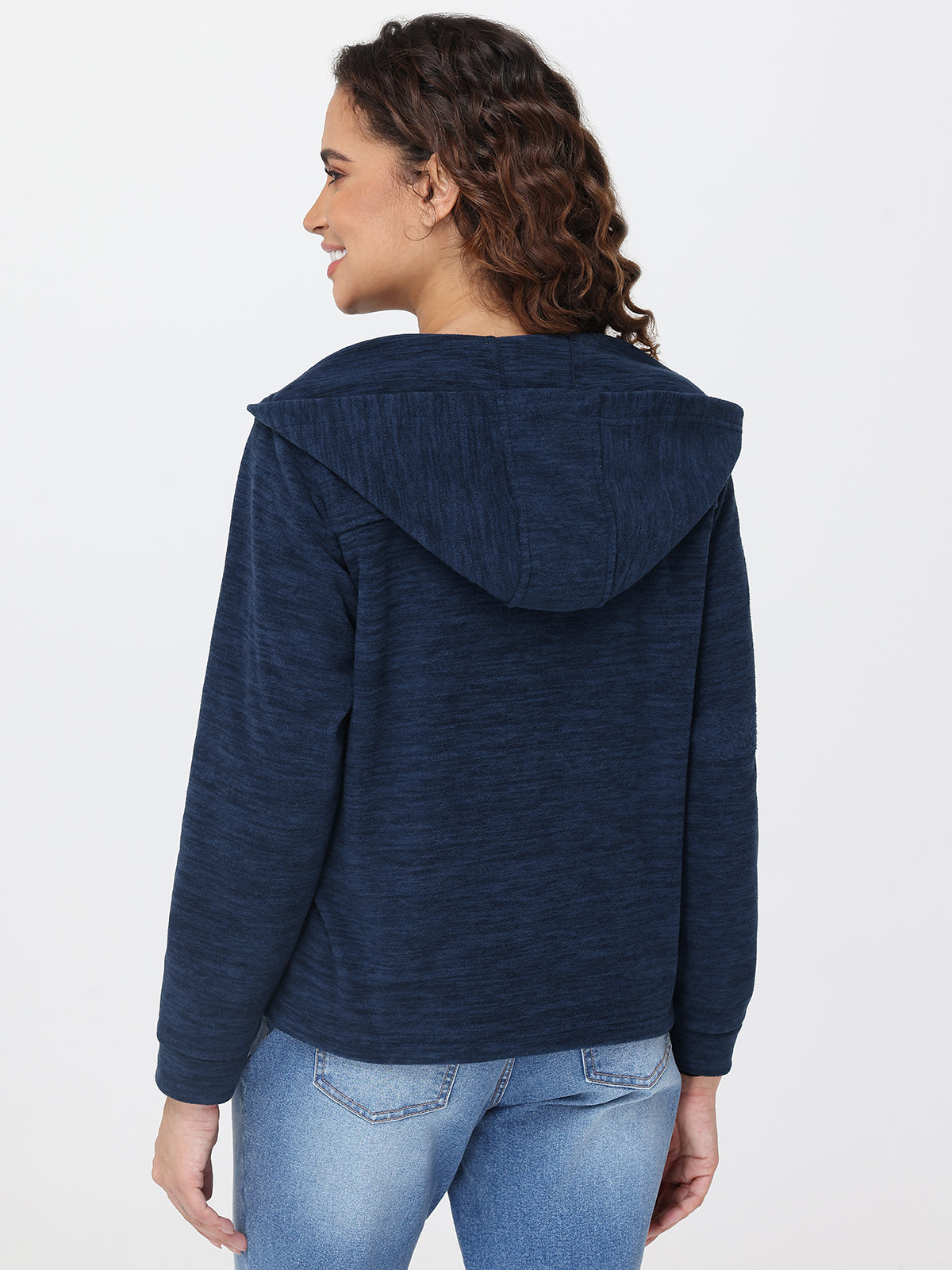 Woman wearing a blue hoodie and jeans on a white background