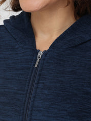 Close-up of a person wearing a navy blue zip-up hoodie with a focus on the zipper.