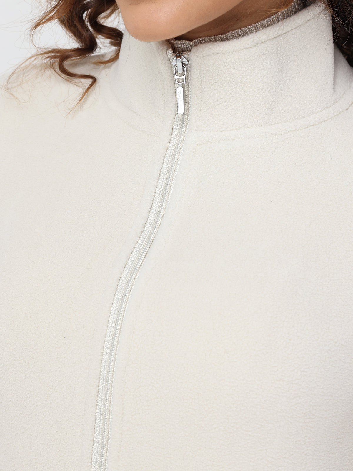 Close-up of a beige fleece jacket with a zipper