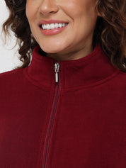 Close-up of a person wearing a red fleece jacket with a zipper.