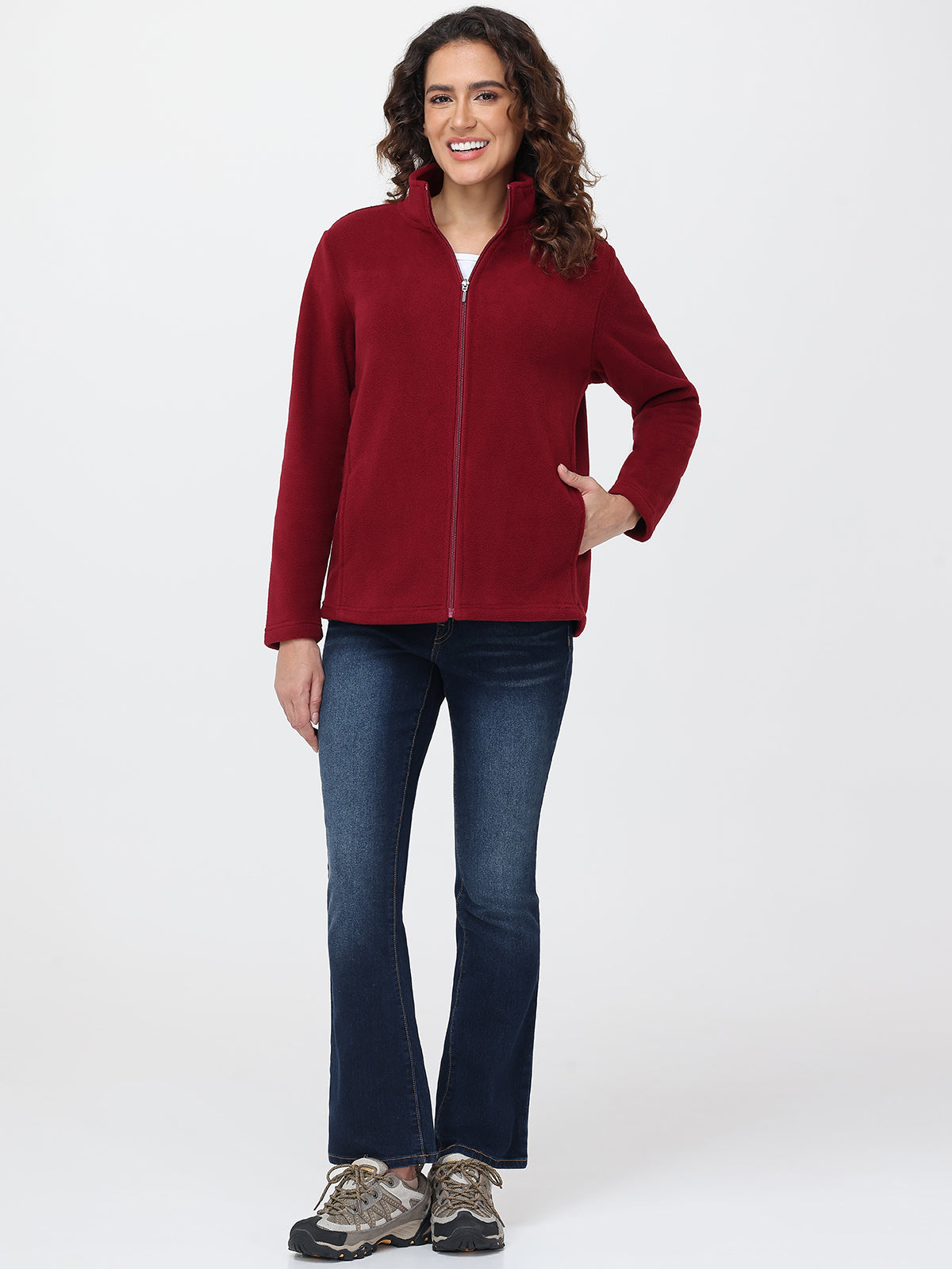 Woman wearing a red jacket and blue jeans on a white background