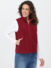 Woman wearing a red vest over a white shirt with a plain background