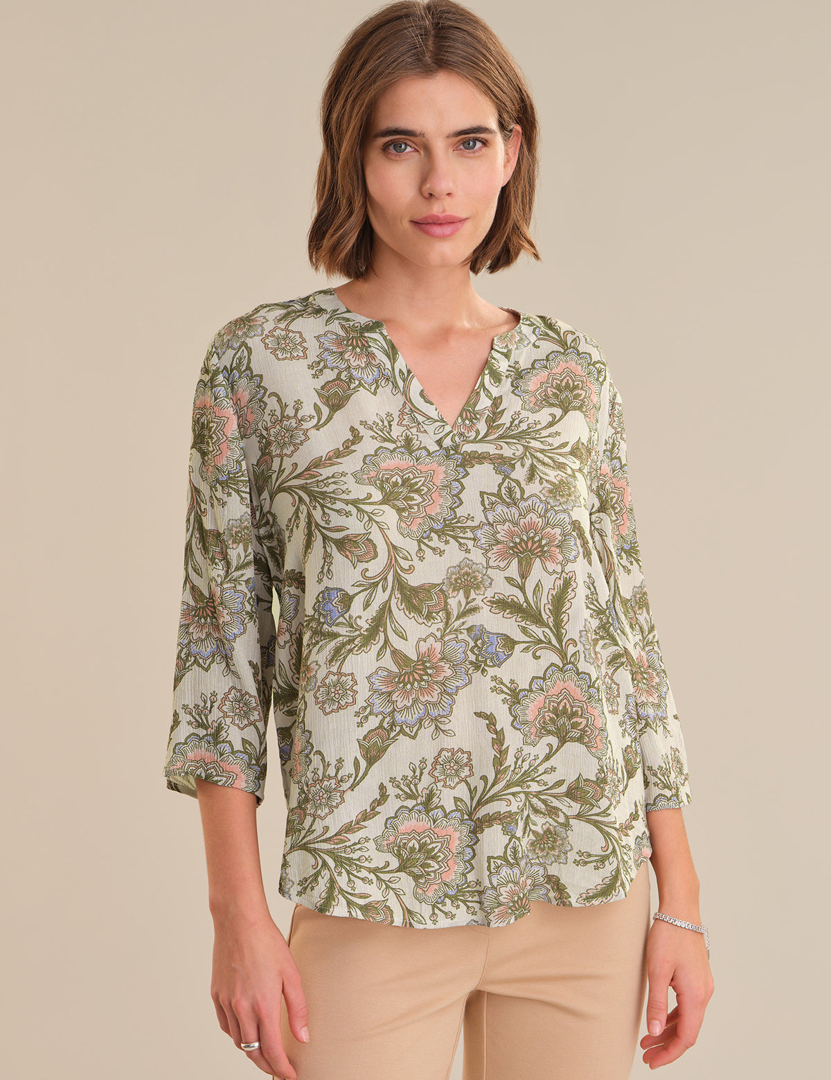 Woman wearing a floral blouse with a neutral background