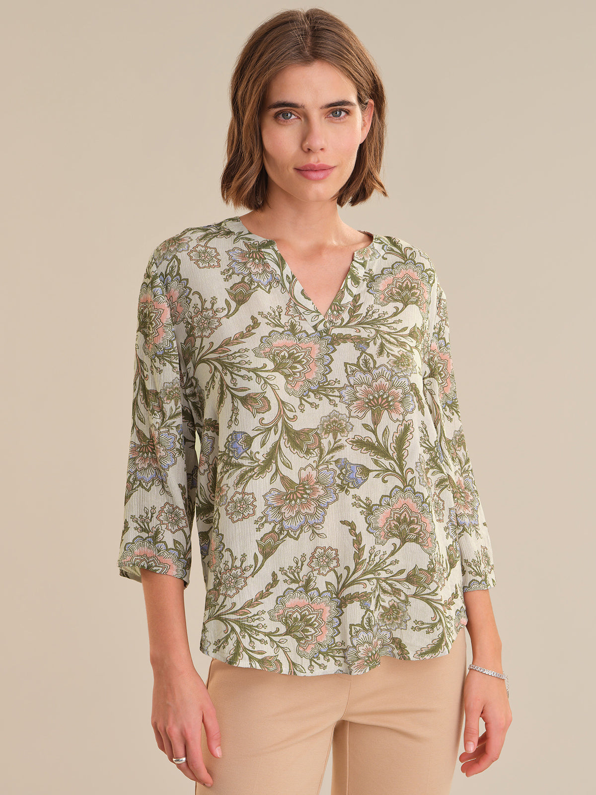 Woman wearing a floral blouse with a neutral background