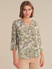 Woman wearing a floral blouse with a neutral background