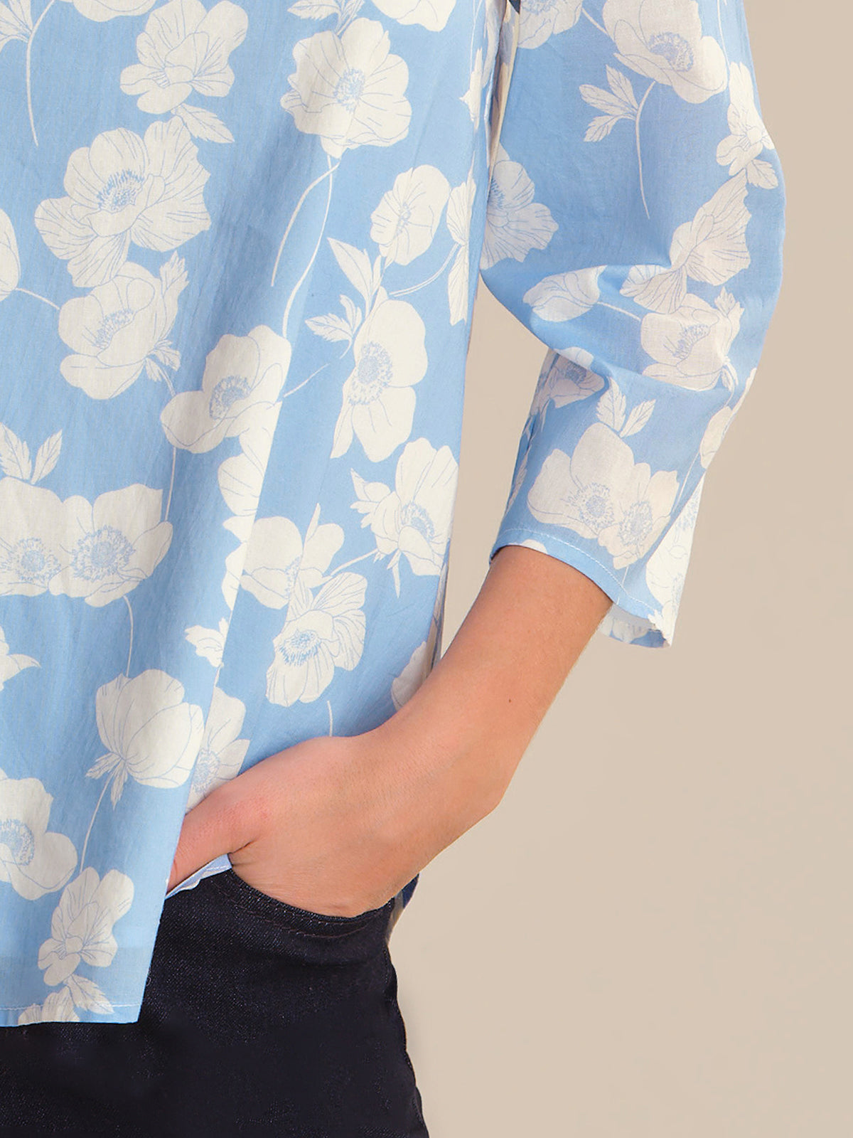 Light blue floral blouse with a beige background