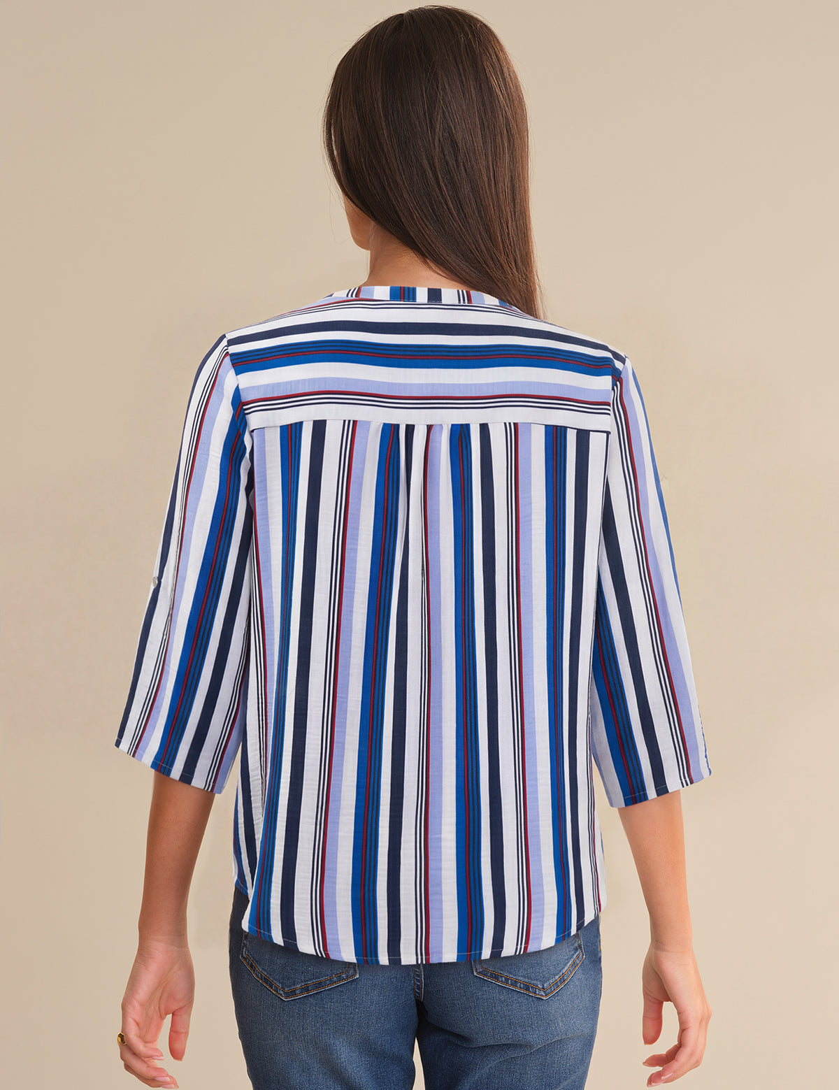 Woman wearing a striped shirt with a beige background