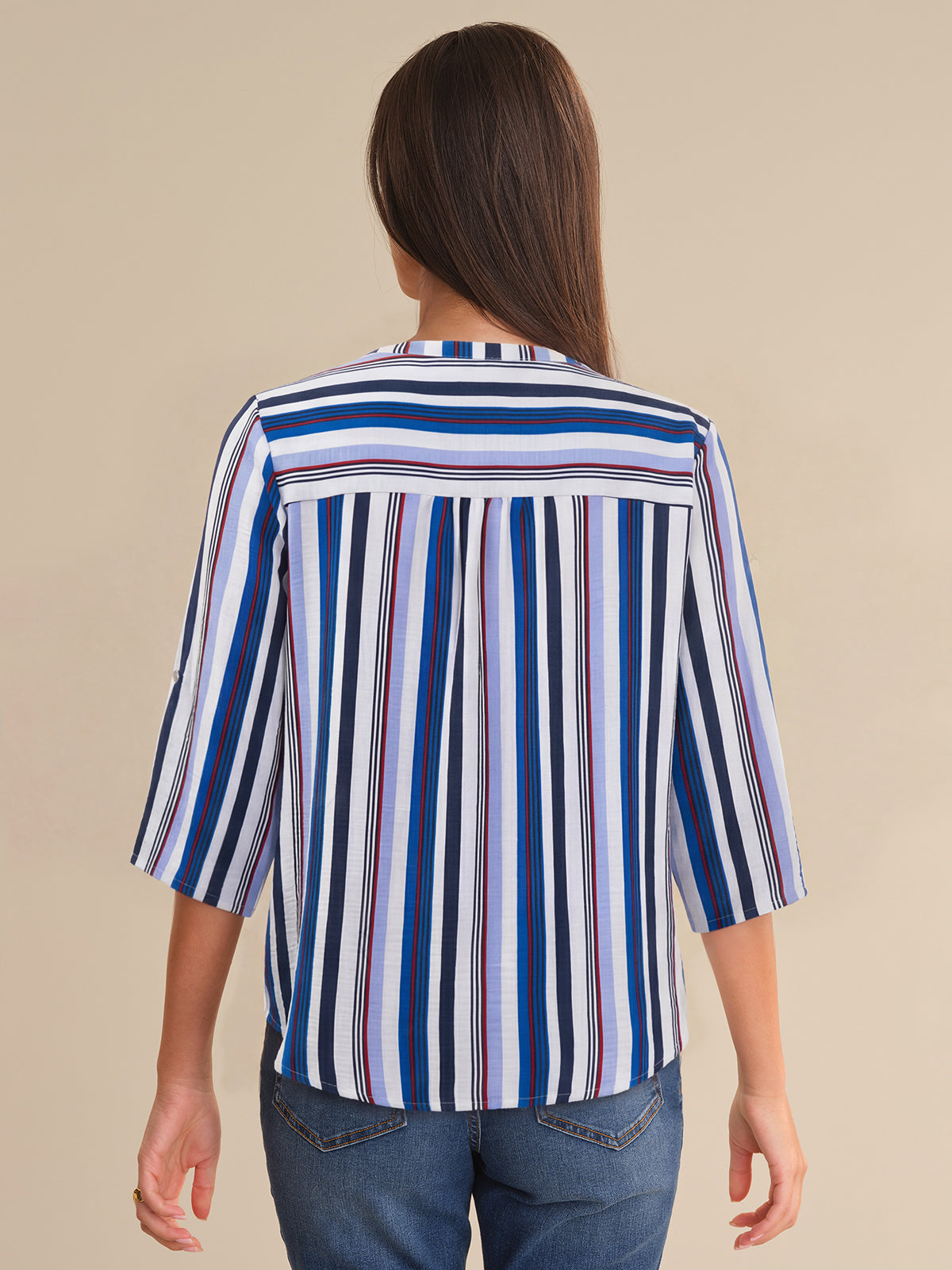 Woman wearing a striped shirt with a beige background