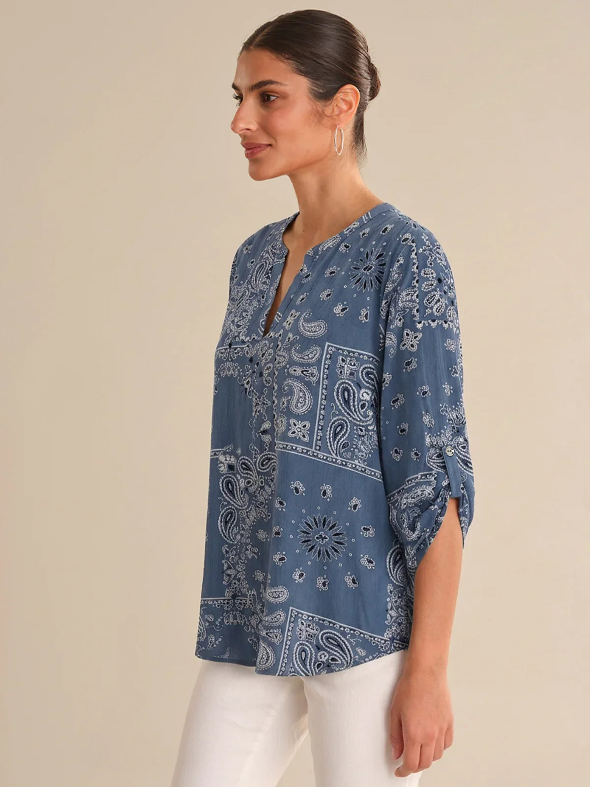 Woman wearing a blue patterned shirt against a beige background