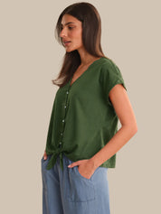 Woman wearing a green top with a plain background