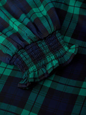 Close-up of green and blue plaid fabric with a focus on texture and pattern.