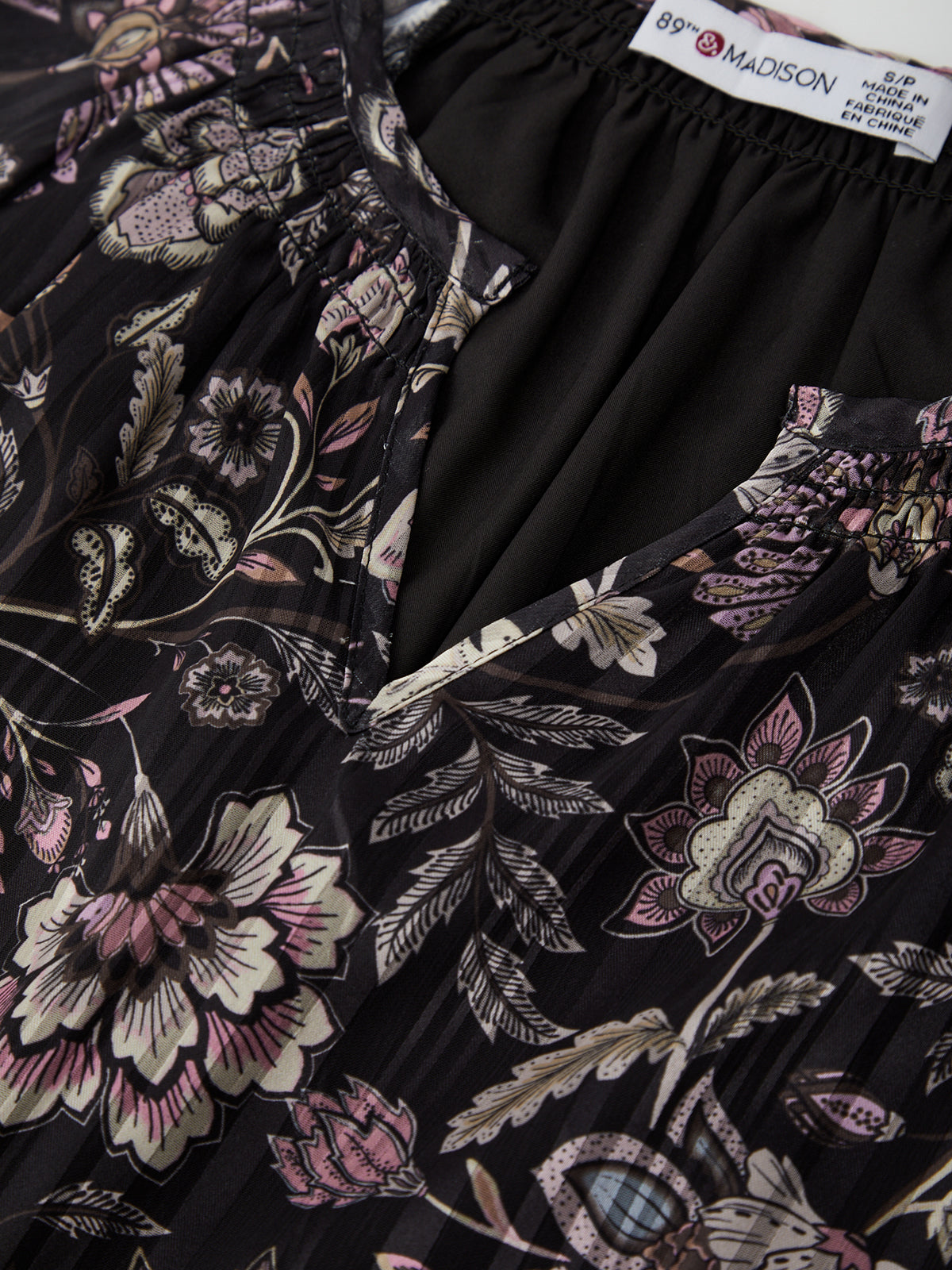 Floral patterned garment with a visible brand label on a black background