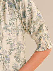 Floral patterned blouse with puff sleeves on a neutral background