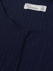 Navy ribbed sweater with a brand label on a matching background