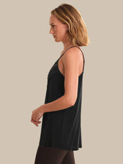 Woman wearing a black sleeveless top against a beige background