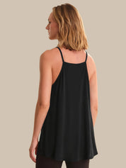 Woman wearing a black tank top against a neutral background