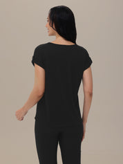 Woman wearing a black t-shirt and pants on a beige background