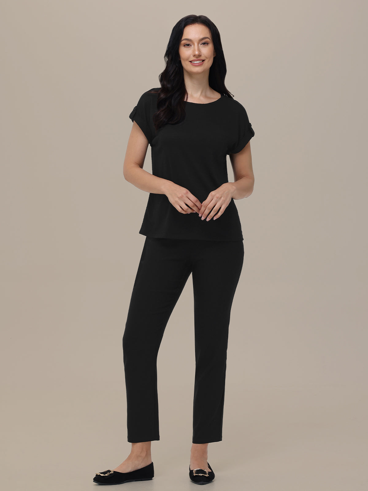 Woman wearing a black outfit on a beige background