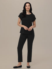 Woman wearing a black outfit on a beige background